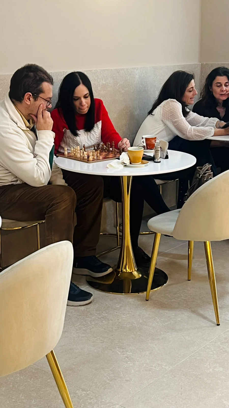 Visitantes disfrutando de una partida de ajedrez y café