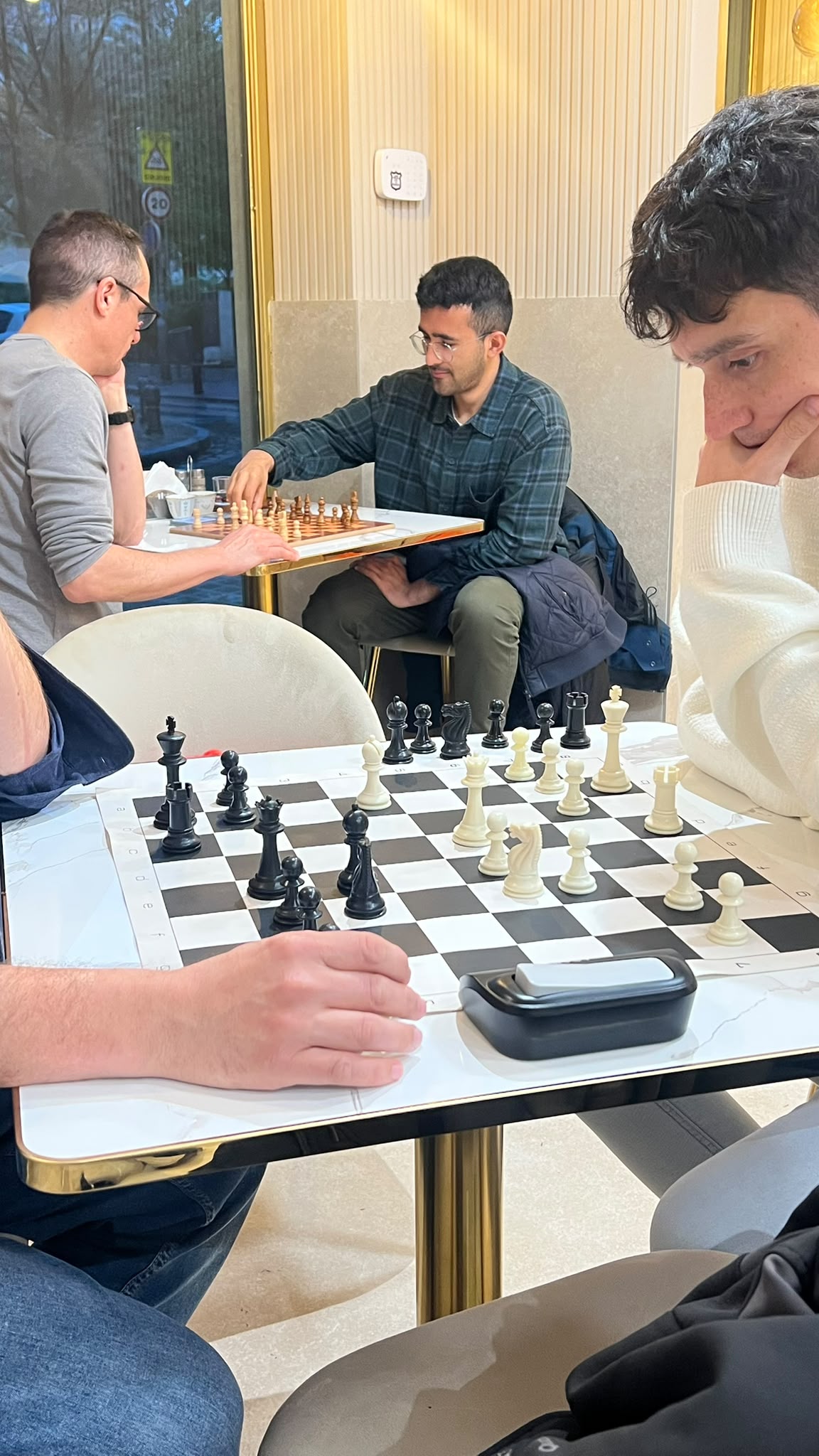 Visitantes disfrutando de una partida de ajedrez y café